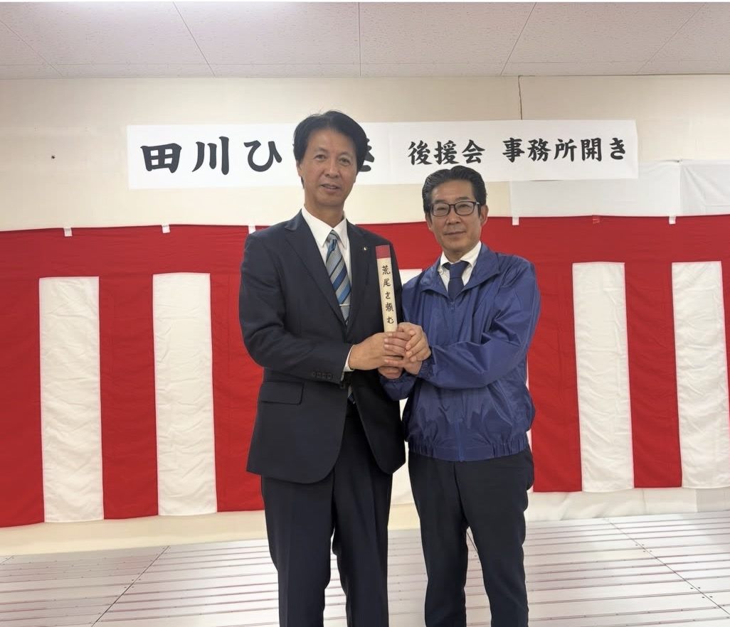 浅田敏彦市長から「荒尾を頼む」と書かれたバトンを受け取る田川ひでき