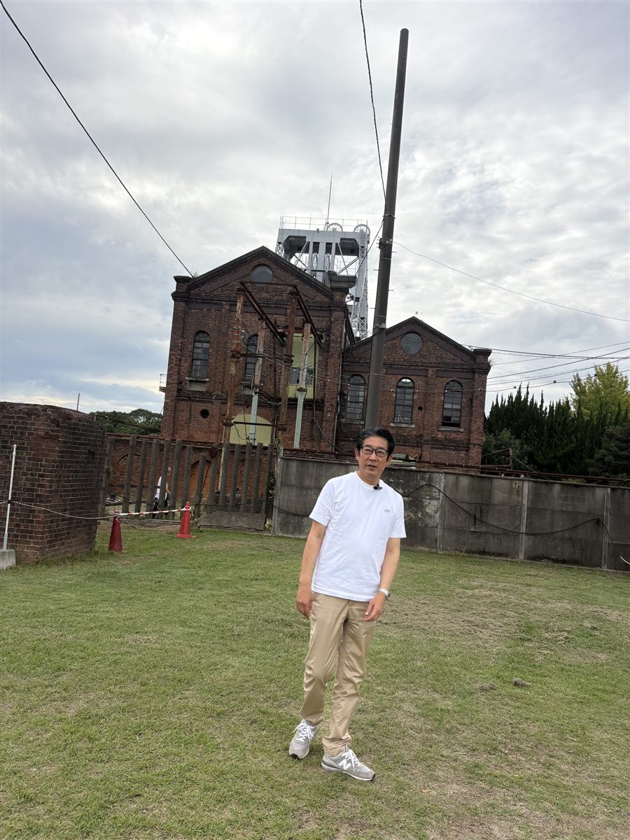 万田坑の前に立つ田川ひでき